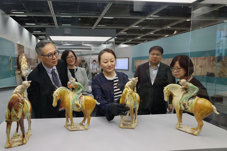 中國文物交流中心展覽處處長羅利君(中)正為珍貴展品「三彩打馬球俑」布展,旁為發展局常任秘書長(工務)劉俊傑(左一)、發展局副秘書長(工務)林雅雯(左二)、文物保育專員梁子琪(右二)及古蹟辦總文物主任蕭麗娟(右一)。