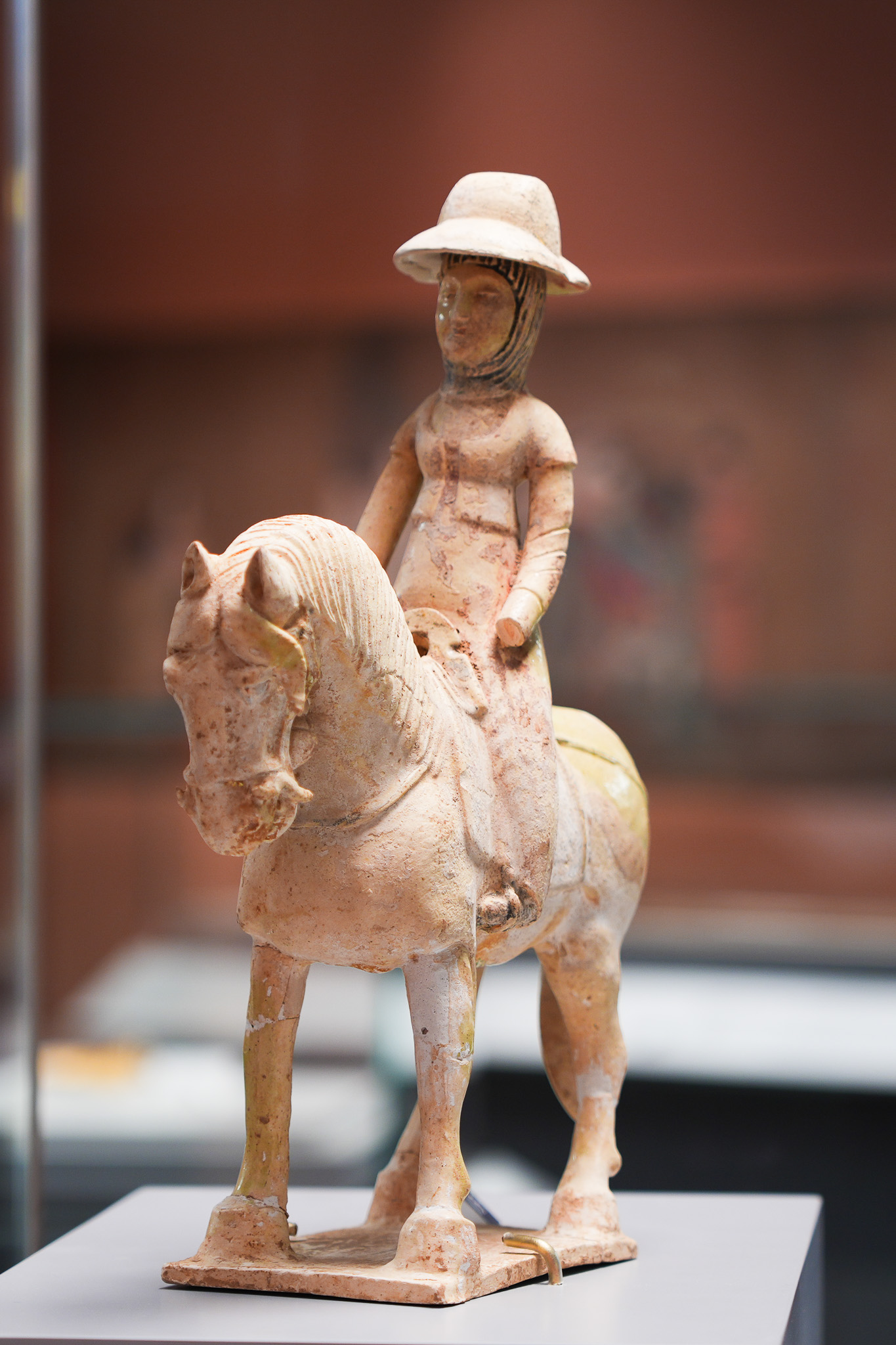 唐朝仕女佩戴以布帛做的軟帽,上方再加斗笠,是武則天時期流行的「帷帽」。(洛陽博物館藏)