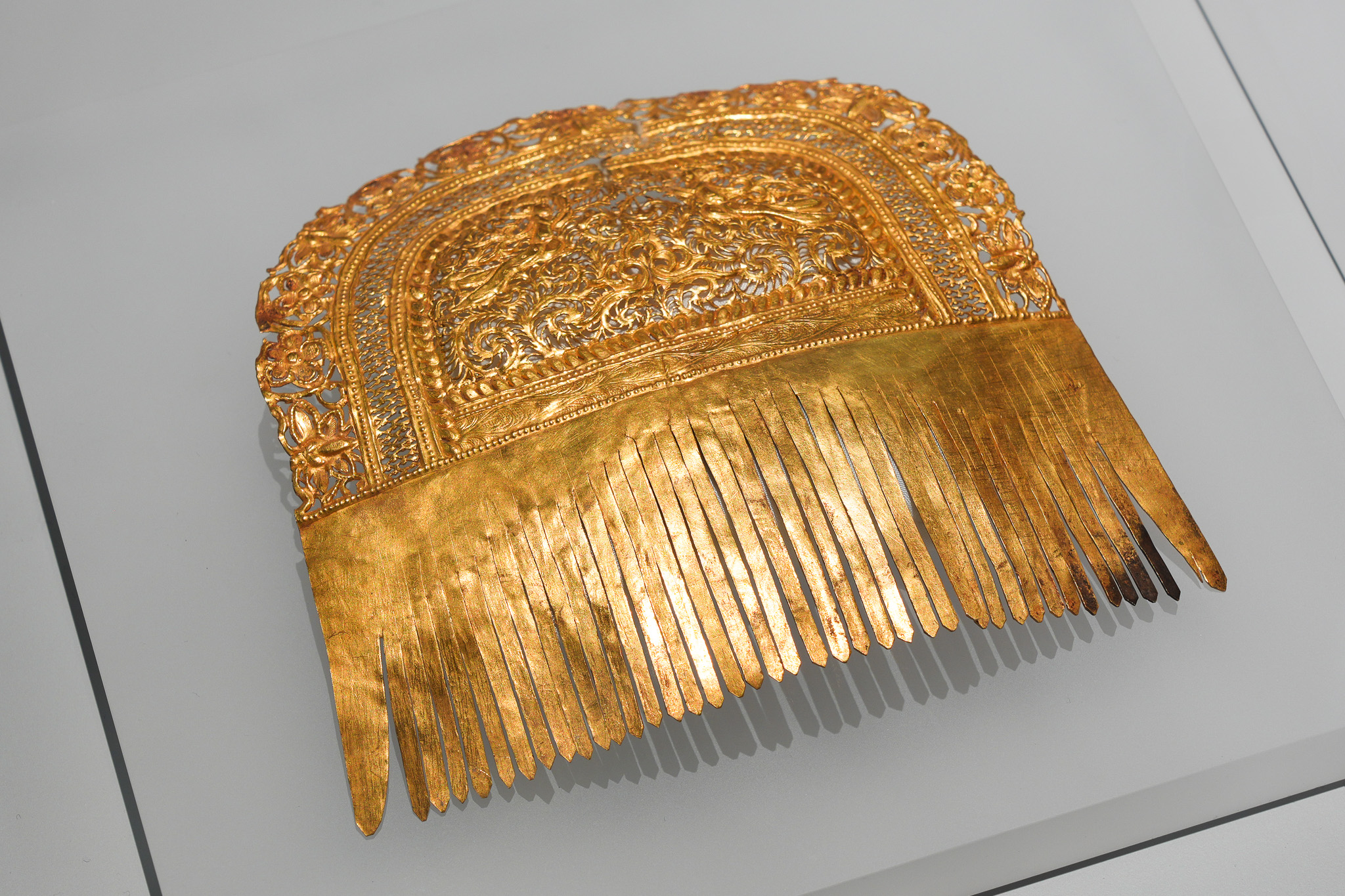 金櫛是插在髮髻上的飾物,這件金櫛於薄薄的金片上刻有一雙對稱的奏樂飛天(即仙女),四周配有多重紋帶,造工華麗。(揚州博物館藏)