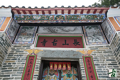 Delicate eaves board and murals above the main entrance