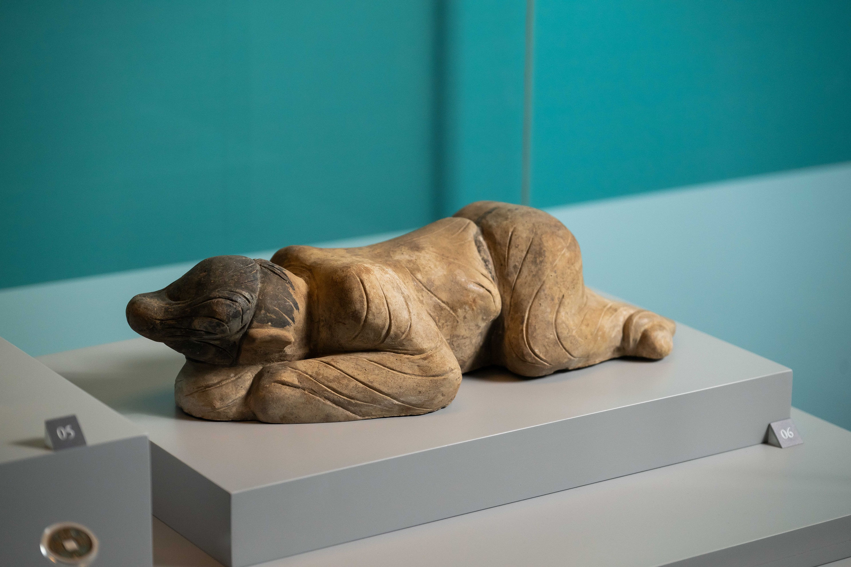 在甘肅慶城穆泰墓出土的「彩繪跪爬俑」頭部低垂貼近地面，彷彿專注聆聽地下動靜。（慶城縣博物館藏）