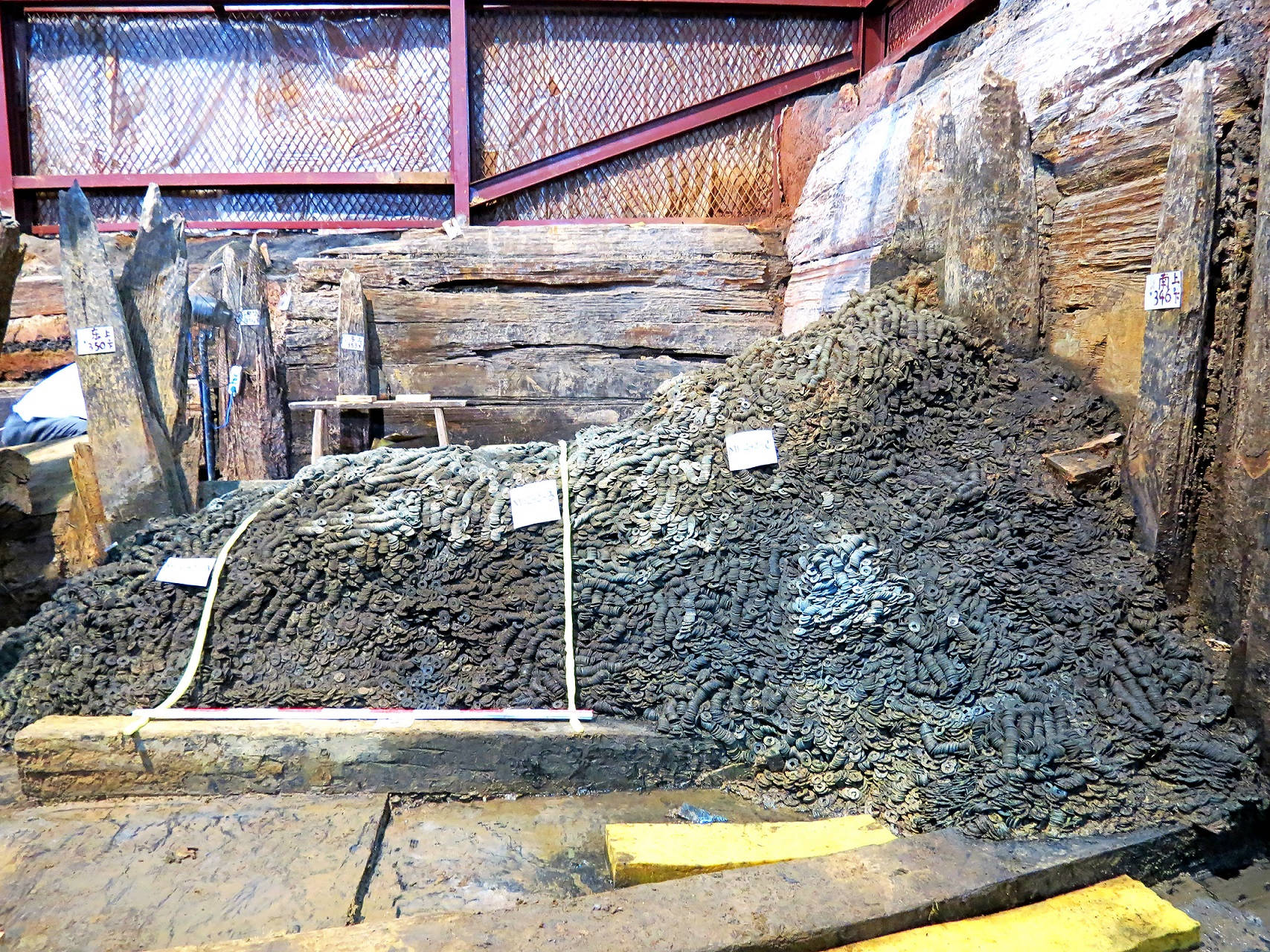 海昏侯墓內的銅錢出土情況，考古隊人員耗時半年點算；每串一千枚銅錢成一貫，展覽展出其中五貫。（南昌漢代海昏侯國遺址博物館提供）