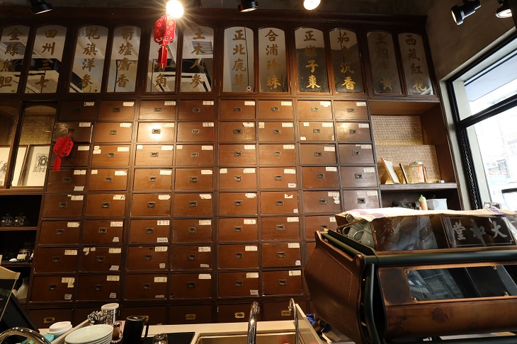 這幢三級歷史建築地下層的藥店活化成咖啡室後,仍保留藥店名號,並以藥店以前盛載藥材的百子櫃用來裝載不同口味的咖啡。