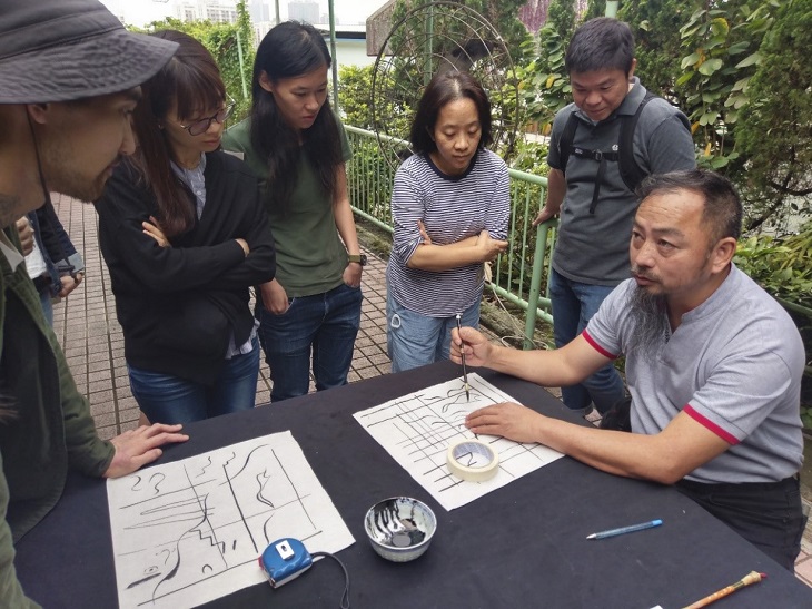 技藝師傅在「隨匠師共藝」傳統建造技藝工作坊向參加者示範傳統繪畫的技巧。