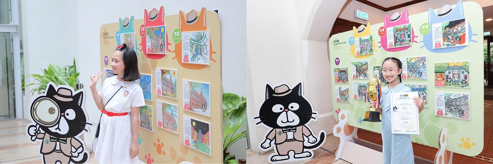 高小組冠軍保良局何壽南小學黎芷悠同學(左)和初小組冠軍大角嘴天主教小學(海帆道) 周雨澄同學(右)在她們得獎作品前留影。