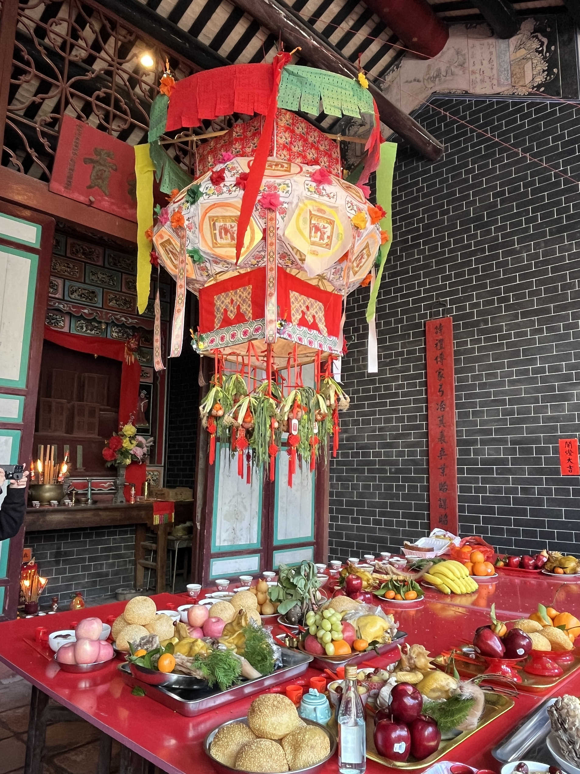 上水廖萬石堂神龕前的橫樑掛上由「燈頭」合力懸掛的大燈籠，神案上擺放祭品。（圖片來源：張瑞威教授）