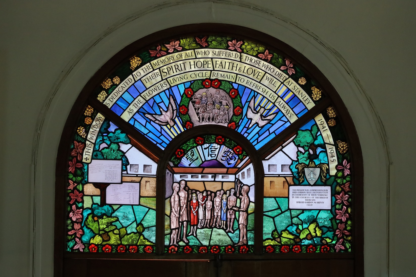 小教堂彩繪玻璃上描繪昔日拘留營的景象，骨瘦如柴的戰俘和飢餓的兒童，聚首禱告，上方一對振翅高飛的鴿子，展示受難者憑着信、望、愛的信念渡過艱辛的日佔歲月。